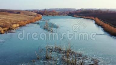 树木在河上结冰生长. 无人机飞过水面.. 湖水湛蓝，树丛和树木从河中生长