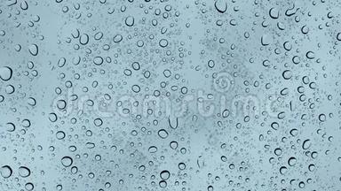 在雨中，在玻璃上特写水滴。 大雨点落在窗玻璃4K上。