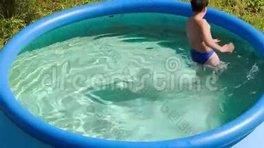 在炎热的夏日在室外游泳池玩耍的男孩