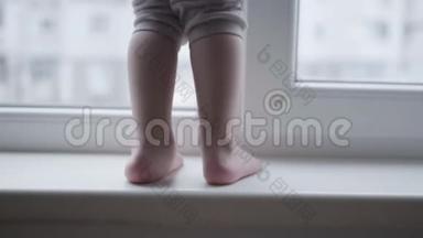 孩子们的<strong>脚踩</strong>在窗台上，危险的小男孩走在靠近窗户的地方。