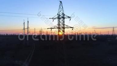 橙色日落背景下的高压电塔、<strong>电力线</strong>路和高压塔的轮廓