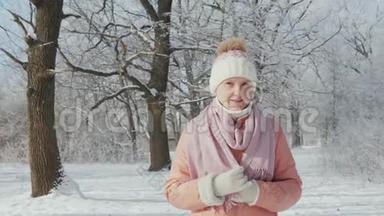 一位中年妇女正在冬天的公园散步，天气晴朗，`下雪