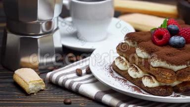 提拉米苏甜点和覆盆子。 蓝莓、咖啡杯和木制咖啡机
