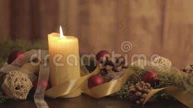 用点燃的蜡烛、松枝、天然松果、红色、金色缎子和