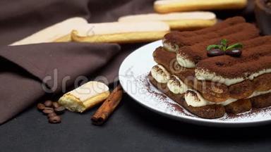 陶瓷盘子上的经典提拉米苏甜点和混凝土背景上的萨沃亚迪饼干