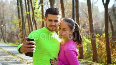 微笑运动情侣在秋季公园自拍