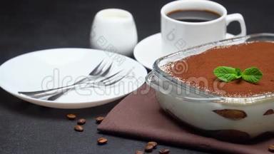 玻璃烤盘中的提拉米苏甜点和混凝土背景下的一杯浓咖啡