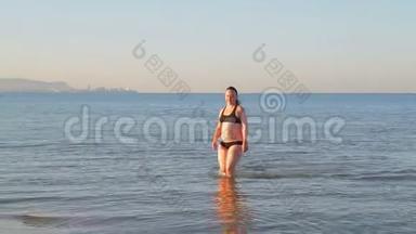 一个穿着运动泳衣的黑发女人在做瑜伽后去海里游泳