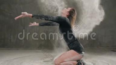 穿着黑色西装的舞女在地板上表演现代舞，用头发<strong>划动</strong>