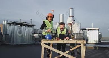 三名建筑工人围着一张<strong>桌子</strong>，<strong>桌子</strong>上放着一个I垫，他们看起来都像在欢快地跳跃