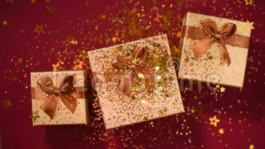 闪闪发光的金色星星，红色背景上的礼品盒上闪闪发光的纸屑。 上景。 圣诞节和新年的纹理。 销售
