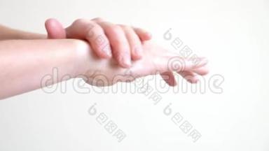一个年轻女人的手在涂手霜，按摩
