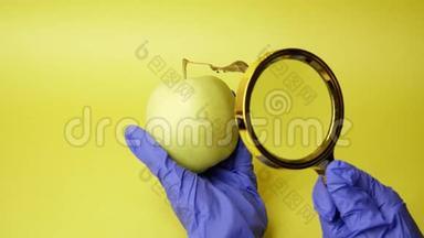 注射到苹果里。 在黄色背景上用注射器交医疗手套。 转基因食品。 注射转基因生物。