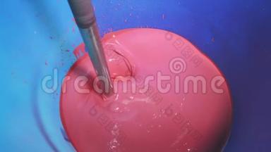 混合油漆在一个桶，混合油漆在一个工厂，工厂自动混合颜色。 在工厂里混粉色漆