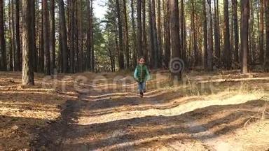 一个学龄前的男孩在森林或公园里沿着道路<strong>奔跑</strong>，体验情感：快乐、快乐和笑<strong>声</strong>。 儿童游戏