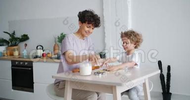 在家里和照顾孩子的母亲在<strong>餐桌</strong>旁做糕点的<strong>小</strong>孩