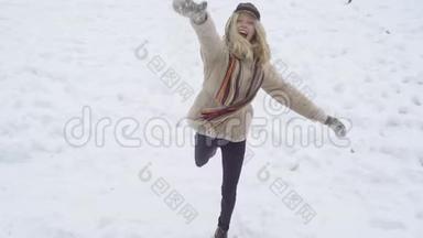 冬天的女人玩雪球。 金发美女做雪球。 冬天与雪的游戏。