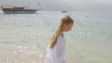 穿着白衣服的快乐少女走在海边。在夏日海滩的海水上散步的旅游女孩。旅游