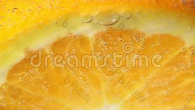 果汁柑橘橙果在水中特写气泡。 准备果汁和饮料