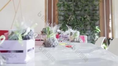 在一张桌子上布置了一个花卉布置的组件，相机接近远处的组件