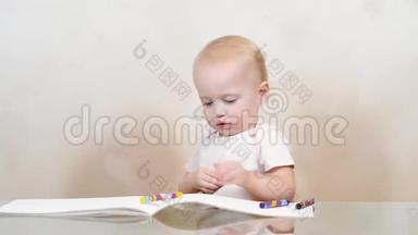 一个小女孩把蜡笔涂在相册上，一张卷到地板上。