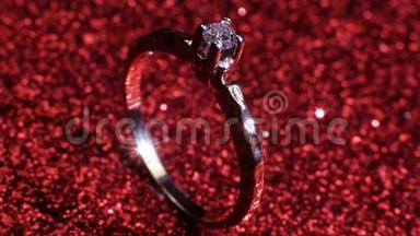 美丽闪亮的金色订婚戒指与大宝石<strong>钻石</strong>在闪光的红色背景。 <strong>情人节</strong>`礼物。