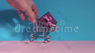 购物车充分收集购物时间.. <strong>电子商务</strong>，礼品购物。 在蓝色粉红色的背景上。
