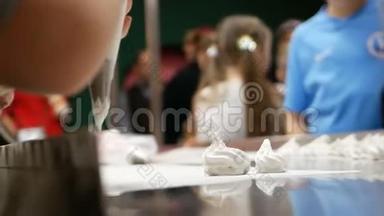 在准备棉花糖的大师班，厨师用糖果袋奶油和羊皮纸紧紧握住厨师的手