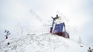 滑雪场和滑雪T杆升降机在斜坡，手持。 小镇下着雪，滑雪者在冬天使用地面升降机。 攀登到
