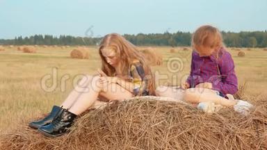 两个十几岁的女孩在乡间的收割场<strong>上</strong>的<strong>干草</strong>堆<strong>上</strong>放松。 少女和少年正在睡<strong>干草</strong>