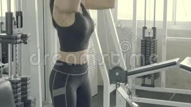 漂亮的年轻亚洲女人在健身房用手在机器上做<strong>下拉</strong>式锻炼