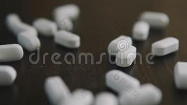 许多白色药物胶囊和药物都落在桌子上特写