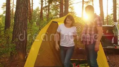 在<strong>露营</strong>帐篷背景下快乐的一对。 在<strong>露营</strong>地拥抱阳光景观的情侣。 旅游夫妇
