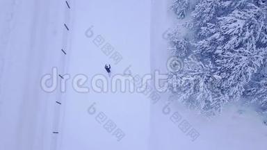 在美丽的蓝松树的雪覆盖滑雪道上进行无法辨认的男女滑雪者训练的空中<strong>观看视频</strong>