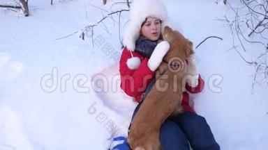 孩子在雪地里玩狗。 漂亮的女孩和狗在雪地里玩耍。 冬天遛猎狗的小孩