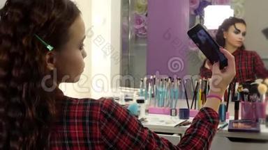 万圣节化妆很简单。 美容院的女孩在智能手机上拍照。