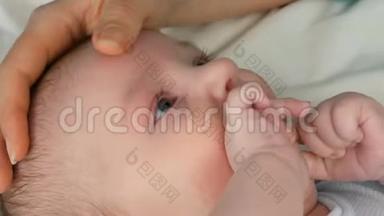 母亲坐在床上轻轻地抚摸并抱着她刚出生的婴儿。 4.这个孩子`了近景