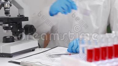 实验室助理对血液涂片进行微生物分析。 概念-血液病，血液