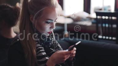 年轻女子用手机，一边发电子邮件，一边坐在咖啡馆A©。 作为一个博主。 现代生活方式。 网上在线