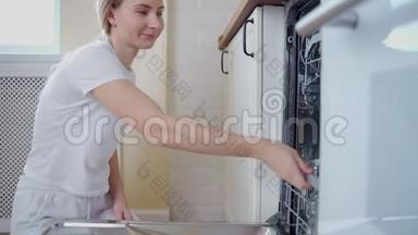 一个女人打开厨房里的<strong>洗碗机</strong>，拿出眼镜