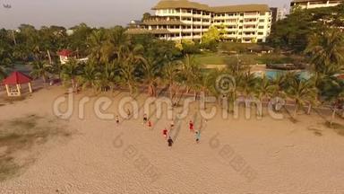 年轻的球员在日落时在海滩上训练。 从上面看到的