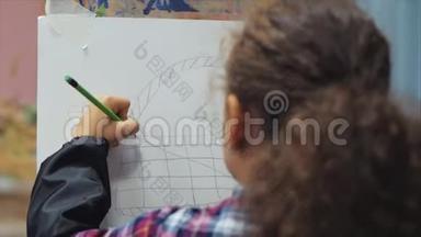 小女孩艺术家的<strong>小手</strong>，小女人艺术家用画笔画出画布，坐在桌子上画画布