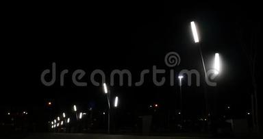 黑暗的夜晚街道上的公共灯和背景上经过的汽车。