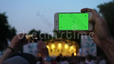 在音乐会上，男人用电话录制<strong>横向</strong>视频。