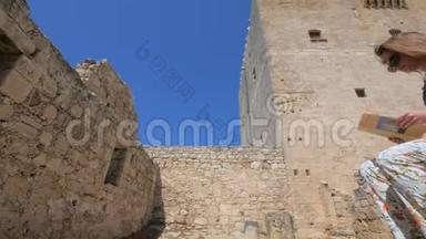 一位女士正在塞浦路斯科洛西城堡附近检查旅游手册
