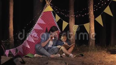在森林野餐时，家人、慈爱的母亲和微笑的女儿在家庭假日里读着童话故事