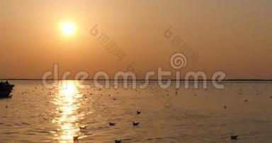 两个渔夫在一艘船上的剪影与橙色日落。