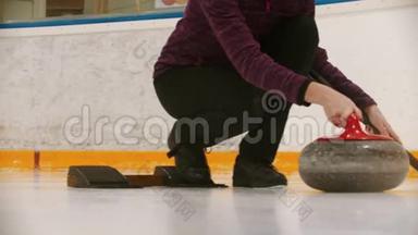 体育综合体中的<strong>冰壶</strong>-一个女人向前推花岗岩