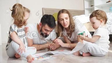幼儿家长与幼儿一起在纸上画水彩画..