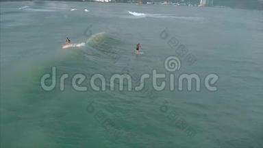 从上面的运动青年男女冲浪，乘坐大浪与明亮的日光，冲浪者正在等待他